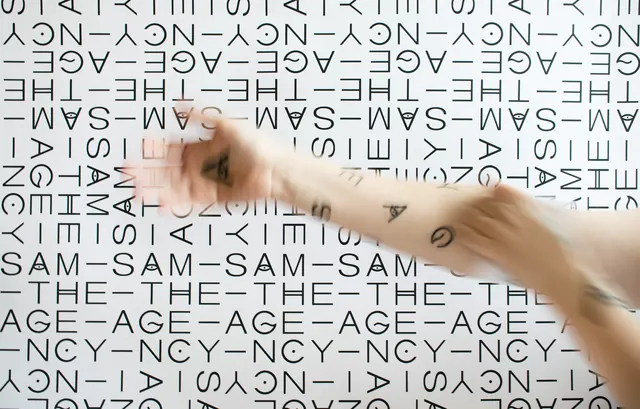 Hands reaching toward branded pattern wall with SAM THE AGENCY, minimal, geometric, monochrome