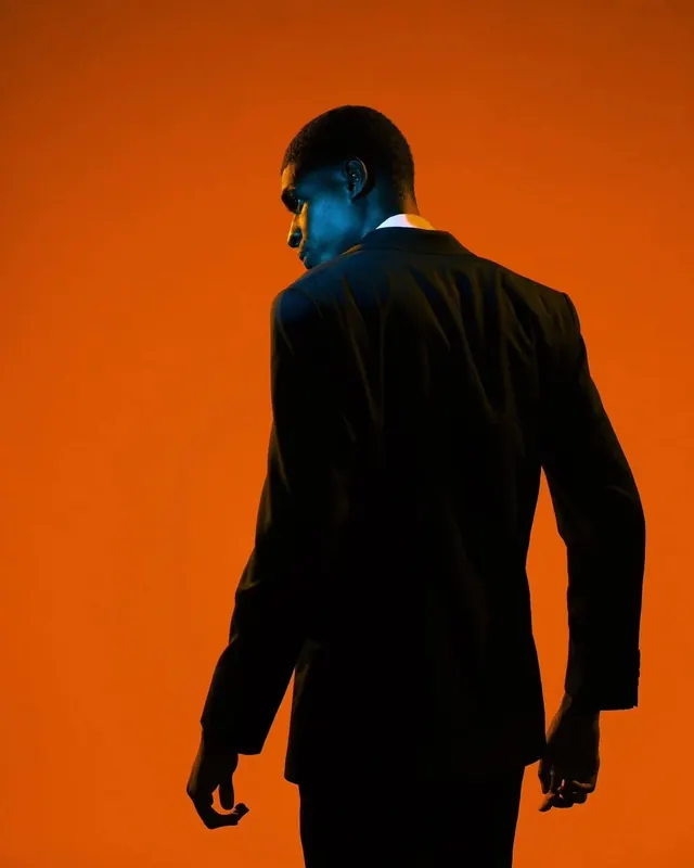 Profile of Man in Suit against Orange Background