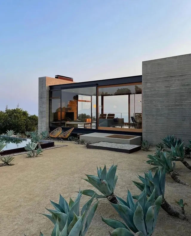 Modern concrete and glass house exterior at dusk, minimal, photographic, light
