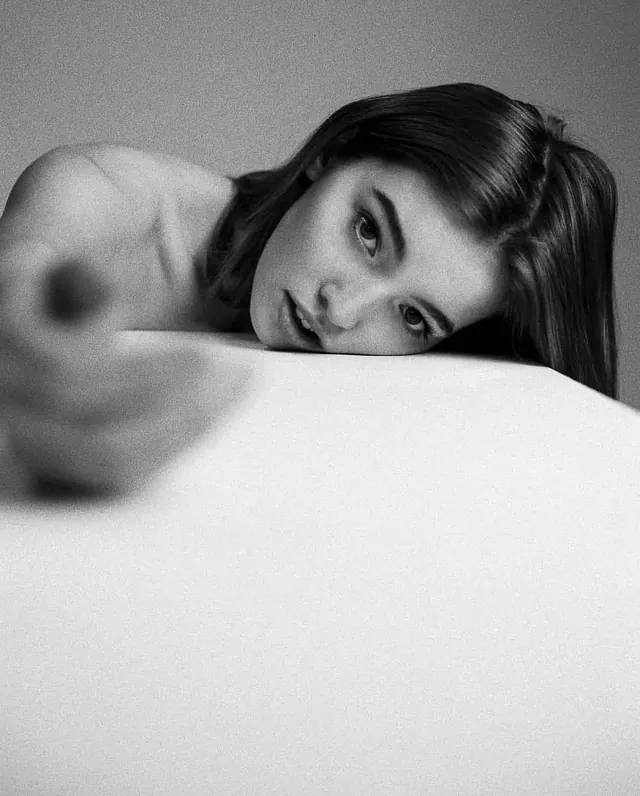 Black and white close-up portrait of woman on white surface, photographic, monochrome, monochrome