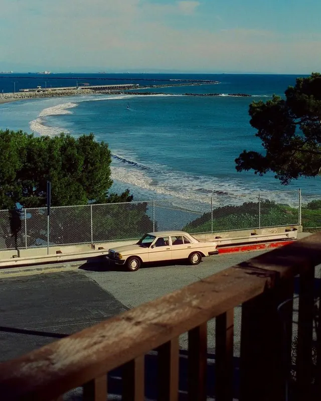 Vintage car overlooking coastal bay, photographic, retro, cool