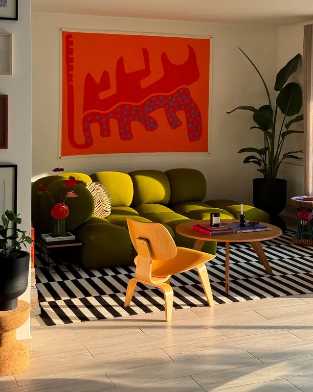 Vibrant living room with orange graphic tapestry and green sofa, playful, geometric, vibrant