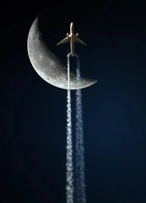 Airplane ascending past crescent moon, photographic, dramatic, dark