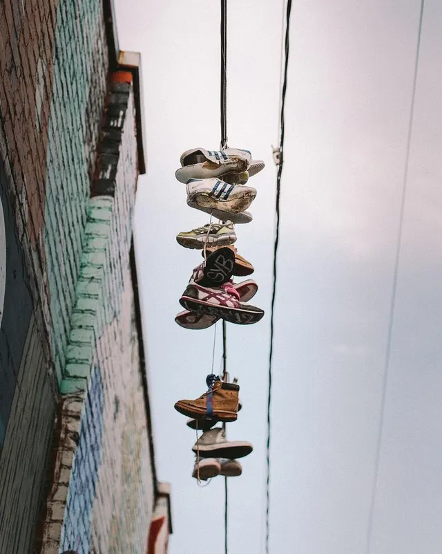 Hanging collection of worn sneakers, photographic, muted