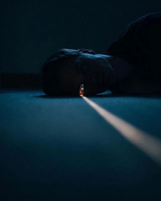Person in Dark Room with Light Beam