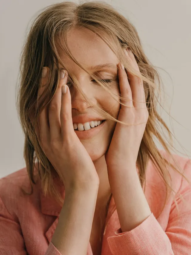 Warm portrait with hands framing face, photographic, editorial, warm