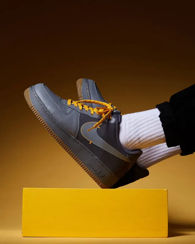 Nike Air Force 1 on yellow pedestal, photographic, minimal, warm