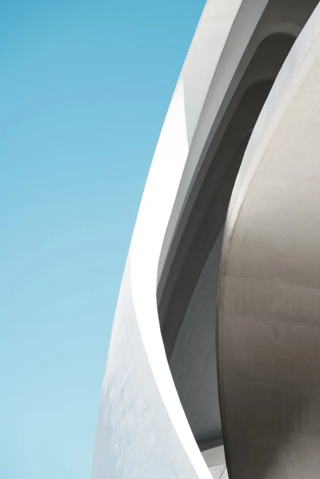 Curved concrete architecture against sky, minimal, photographic, light