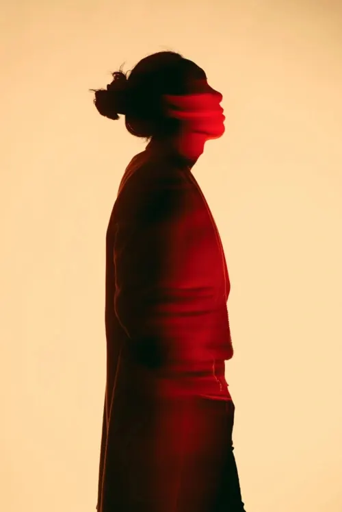 Red-light silhouette portrait, minimal, photographic, warm