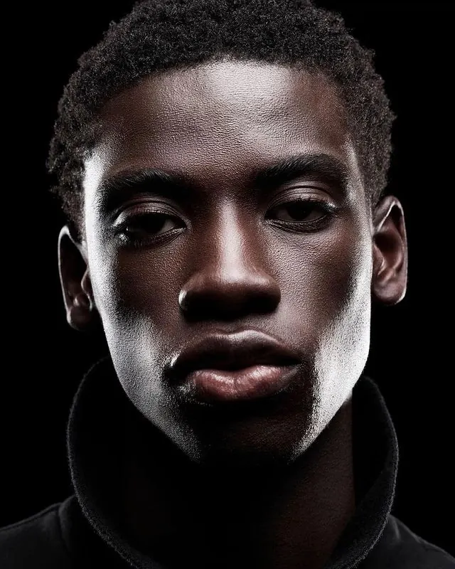 Low-key close-up portrait, minimal, photographic, dark