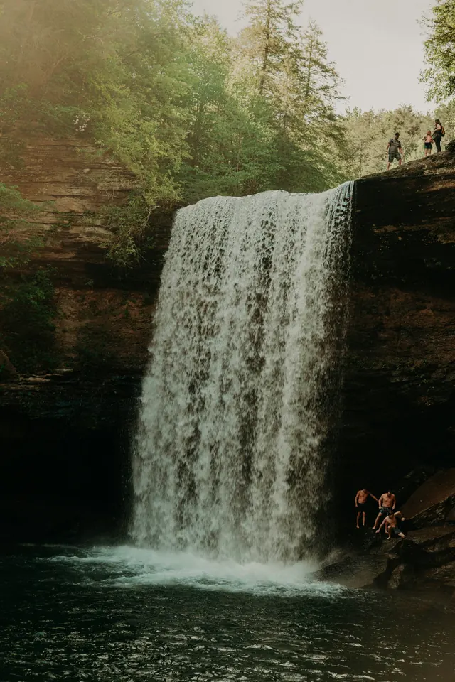 Waterfall with figures for scale, photographic, organic, earthy