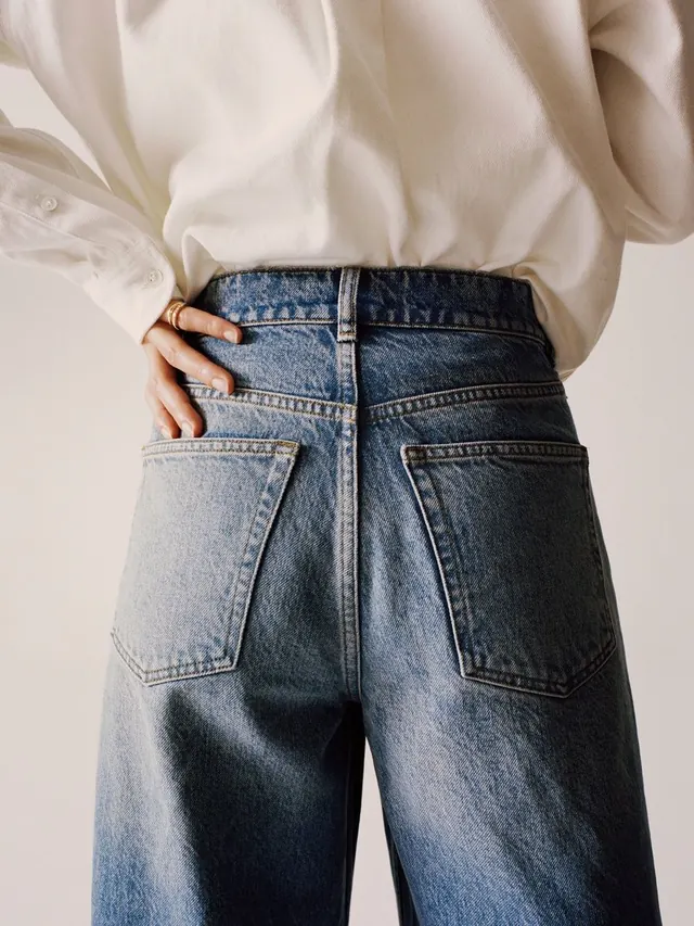 High-waist denim and white shirt detail, photographic, minimal, light