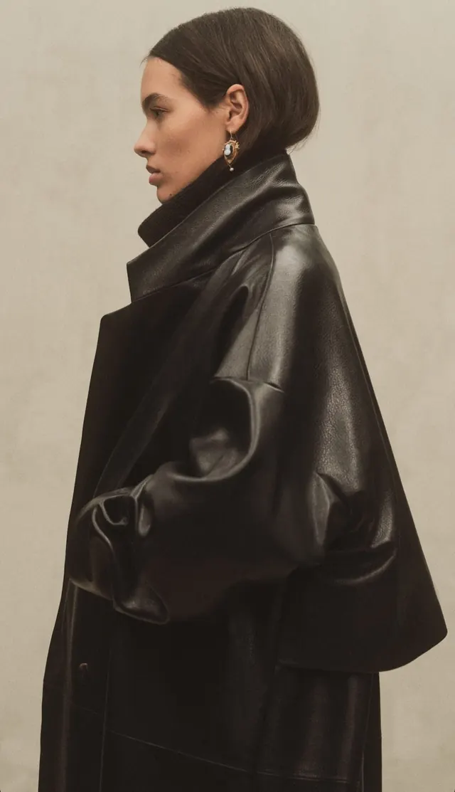 Oversized black leather coat profile, photographic, editorial, monochrome
