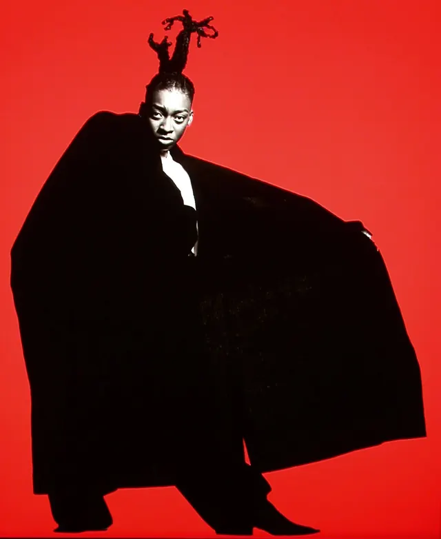 Red field black cape editorial portrait, editorial, photographic, vibrant