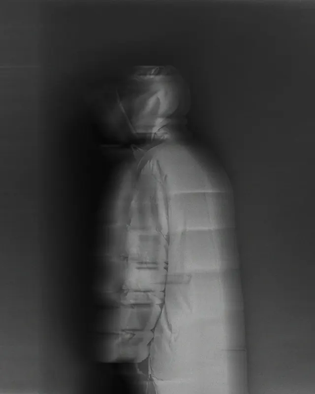 Ghosted puffer jacket motion portrait, photographic, minimal, monochrome