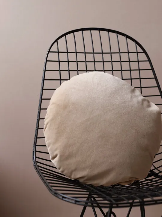 Tan cushion on wire chair, minimal, photographic, muted