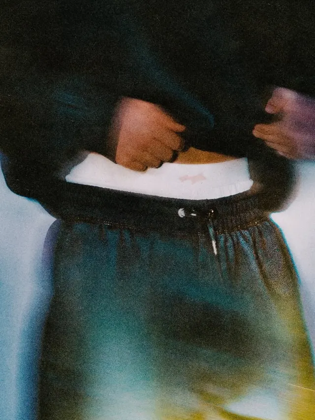 Streetwear waist light-leak close-up, photographic, retro, dark