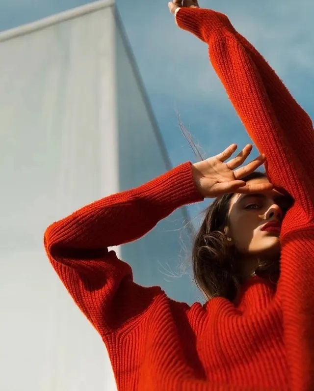 Red ribbed sweater low-angle fashion portrait, photographic, minimal, vibrant