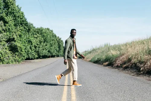 Man crossing rural road fashion shot, photographic, minimal, light