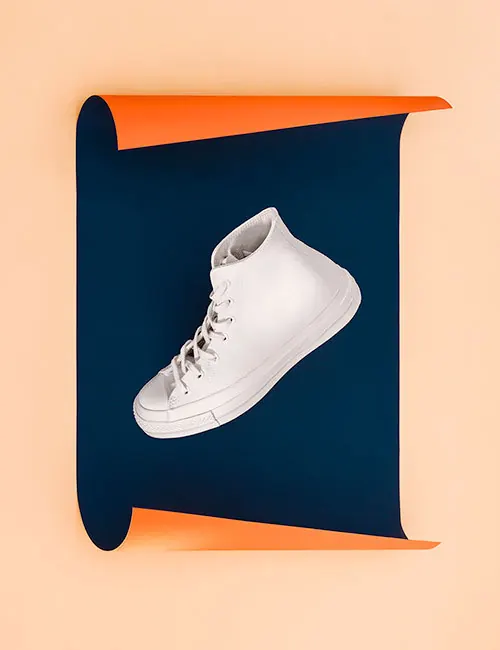 Floating white sneaker on navy scroll, minimal, photographic, light