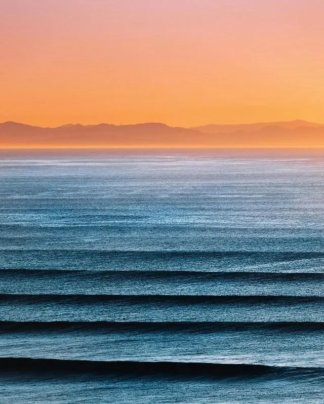Parallel ocean swells at sunset, photographic, minimal, warm