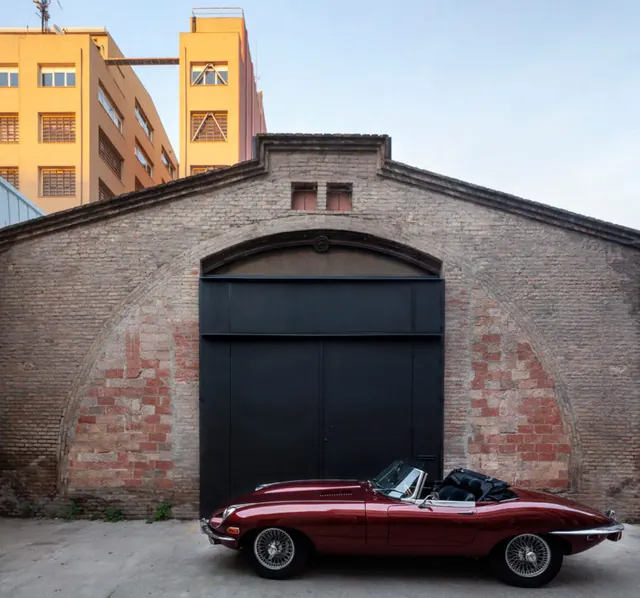 Red Sports Car in Front of Industrial Building, photographic, geometric, vibrant