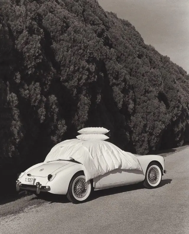 Vintage car tucked in with bedding, photographic, minimal, monochrome