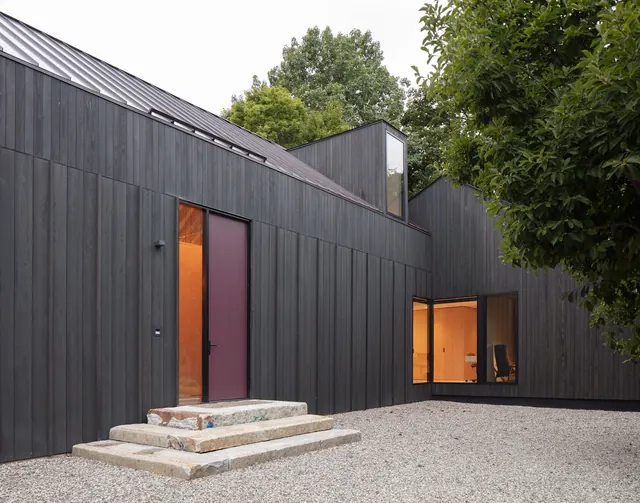 Dark wood-clad modern farmhouse exterior, minimal, organic, dark