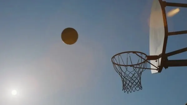 Basketball silhouette against sun, minimal, photographic, light
