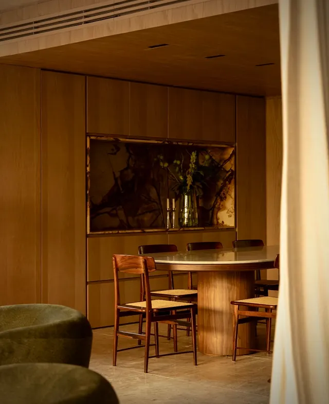 Wood-paneled dining room with backlit stone, minimal, organic, warm