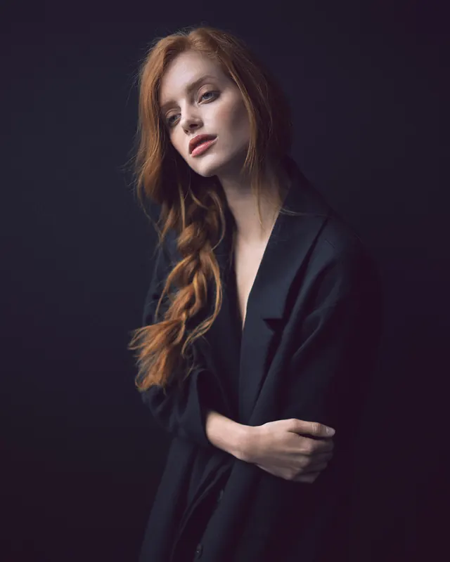 Red-haired woman in dark blazer, photographic, minimal, dark