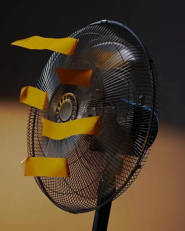 Fan with yellow airflow strips, minimal, photographic, dark