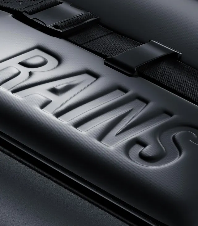 RAINS embossed wordmark product macro, minimal, technical, dark