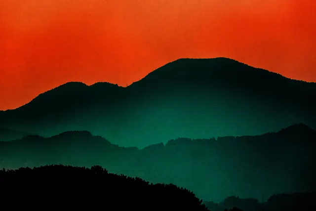 Orange sky layered mountain silhouettes, minimal, photographic, vibrant