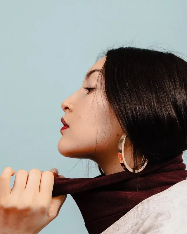 Profile portrait on baby-blue backdrop, minimal, editorial, light