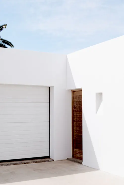 White stucco corner with wooden door, minimal, photographic, light