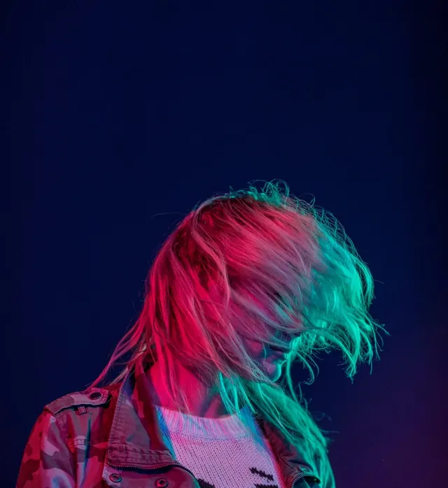 Split color lit portrait with flying hair, photographic, dark-mode, dark