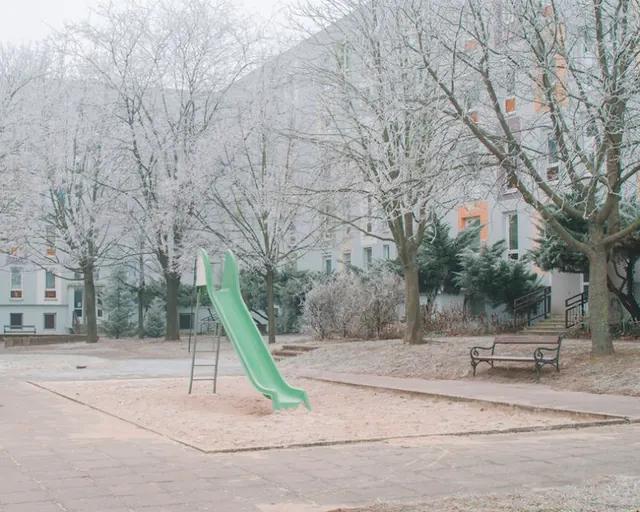 Snowy playground with green slide, minimal, monochrome, muted