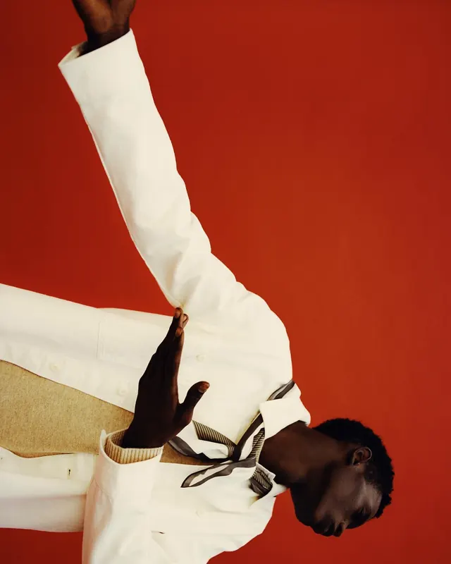 Man in White Suit against Red Background