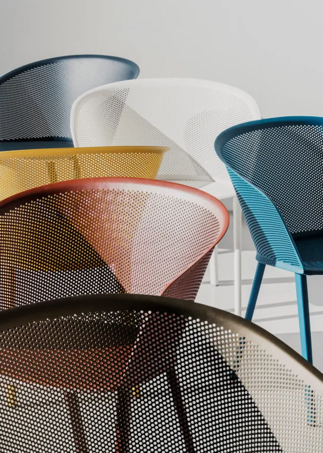 Close-up of colorful perforated metal chairs, minimal, photographic, light