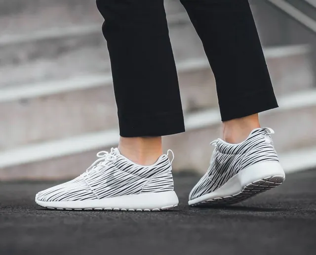Striped white sneakers on pavement, minimal, photographic, light