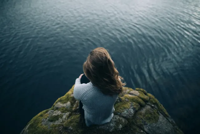 Woman on Rock Overlooking Water