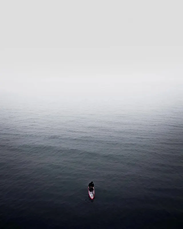 Lone figure on foggy sea, minimal, monochrome, dark