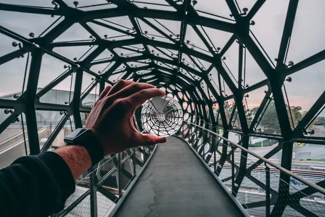 Hand holding glass in geodesic structure