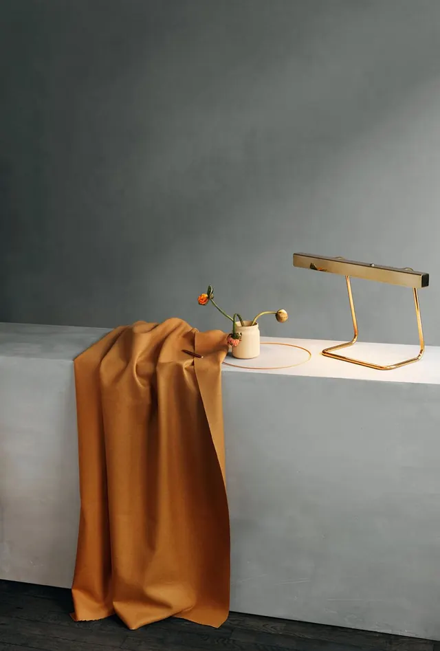 Minimal still life with draped fabric and brass lamp, photographic, minimal, warm
