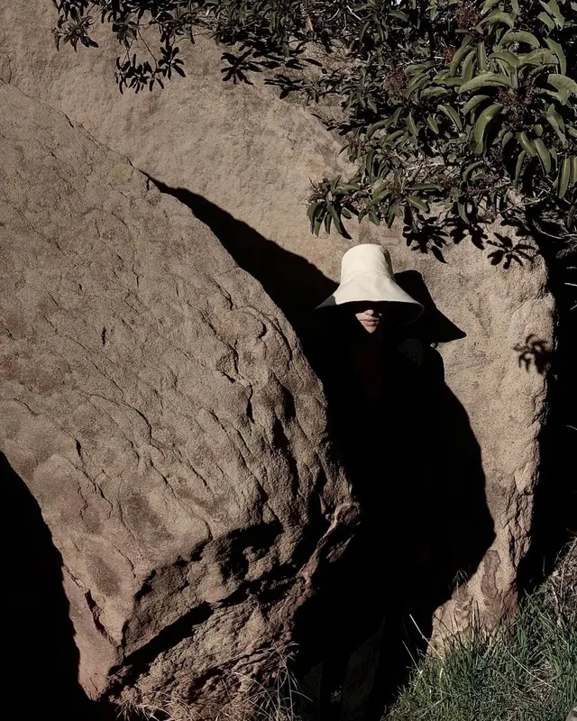 Person in Wide-Brimmed Hat by Rock