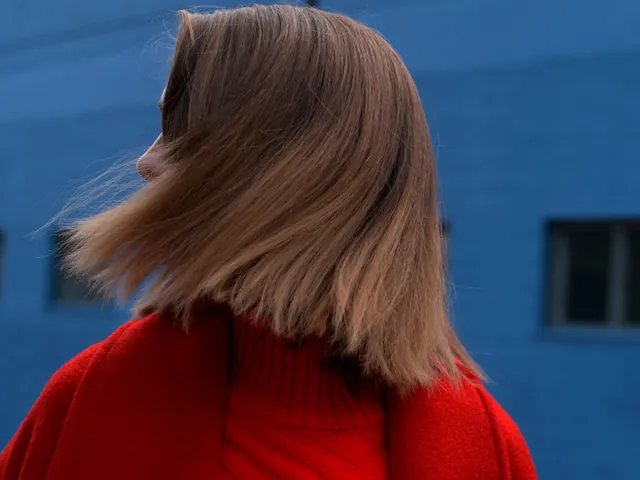 Woman in Red Coat against Blue Wall