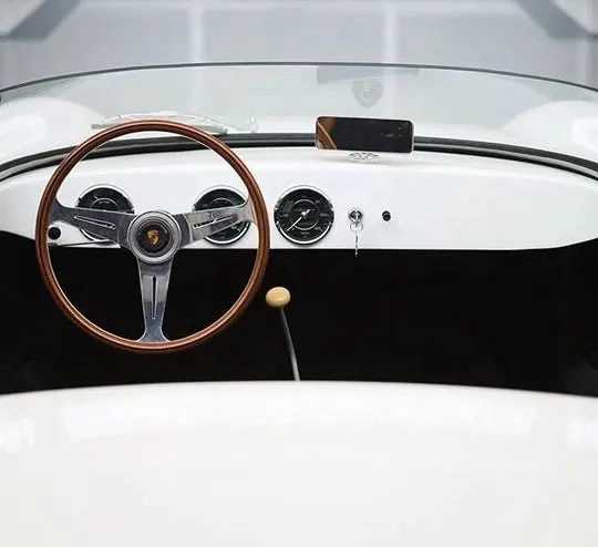 Classic Porsche car interior close-up with wooden steering wheel, photographic, light