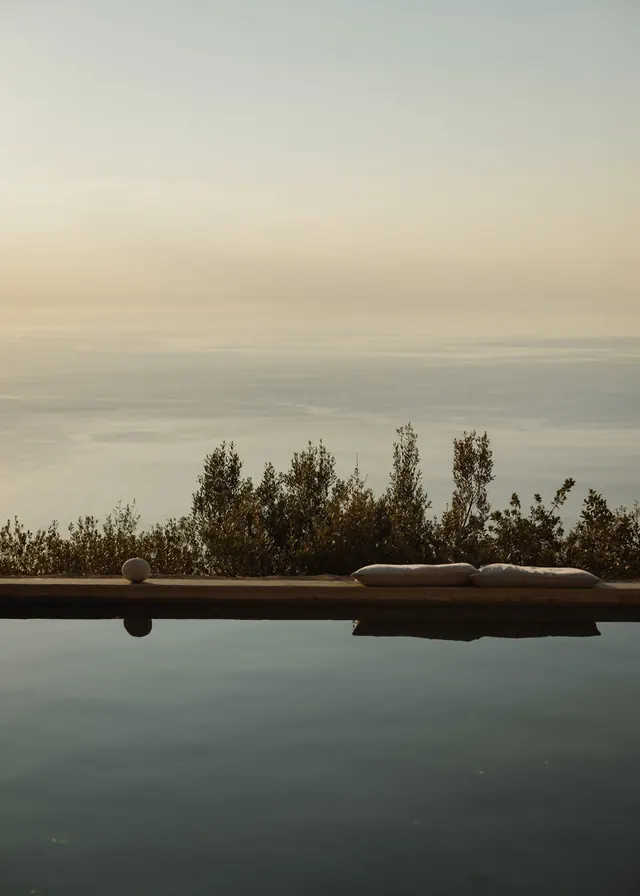 Infinity pool overlooking misty sea, minimal, photographic, muted