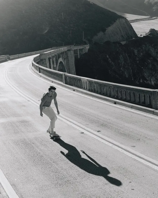 Skater on coastal bridge, photographic, minimal, monochrome